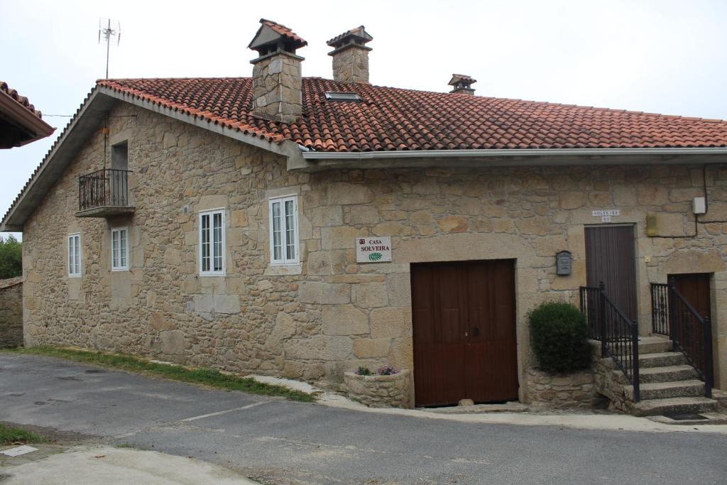 PiñeiroCasa Solveira的石头房子,设有门和阳台