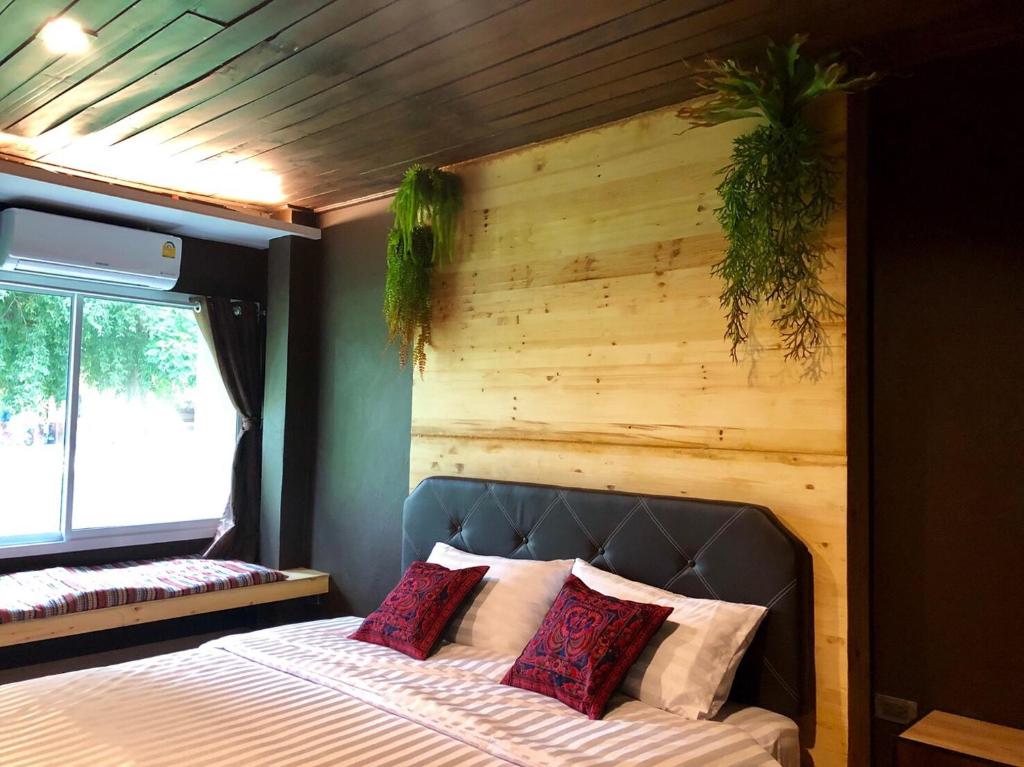南邦Ruankaew Boutique Resort Lampang的一间卧室配有一张木墙床
