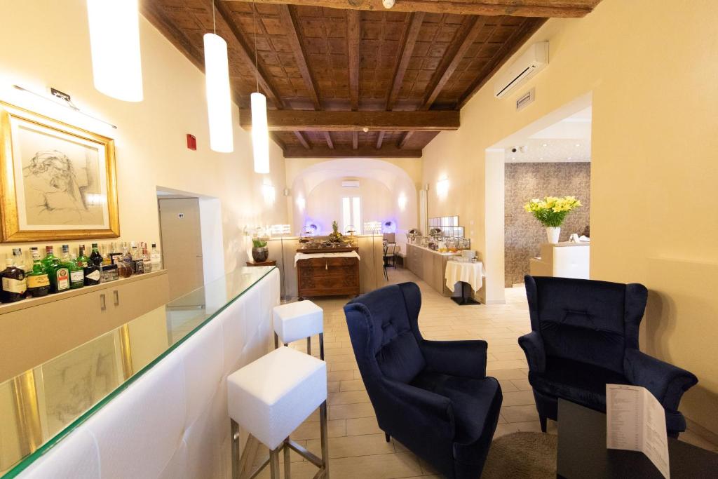 博洛尼亚Albergo Rossini 1936 - Small & Charming的一间设有2把蓝色椅子的品酒室和一间酒吧