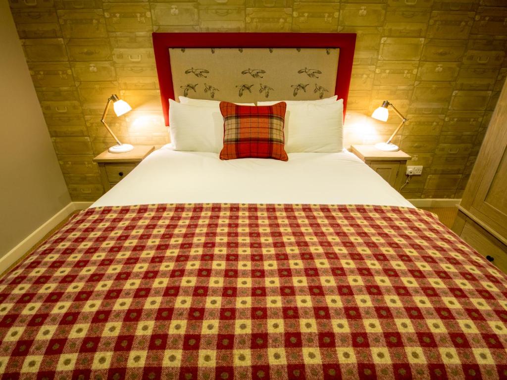 北安普敦The World's End - Northampton的一间卧室配有一张大床和一张铺着条纹毯子
