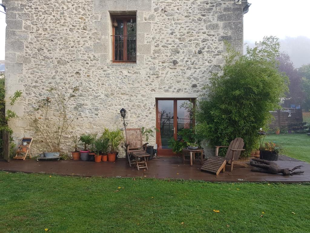 Bonneuil-en-ValoisEn pleine nature的一座带椅子和植物的建筑前的庭院