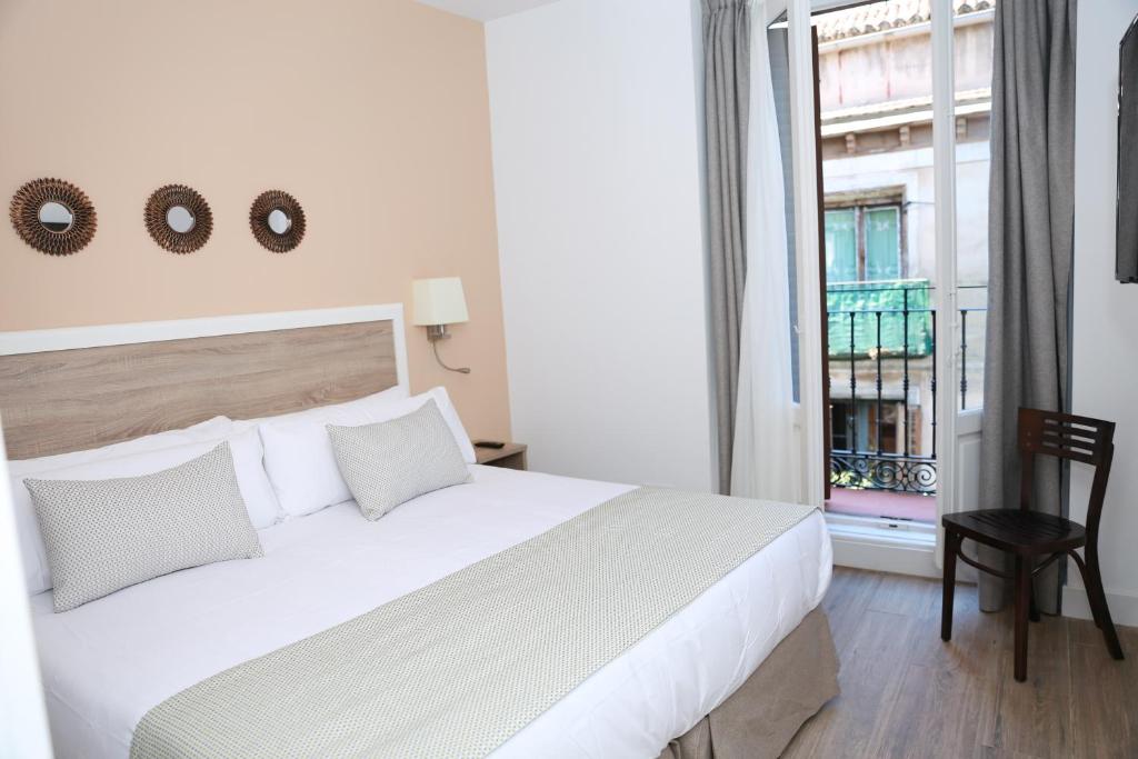 马德里New Point Opera的卧室设有一张白色大床和一扇窗户。