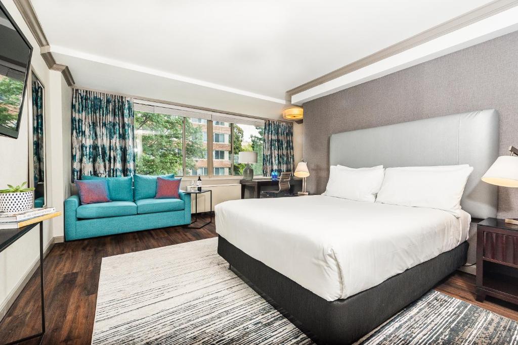 华盛顿The River Inn的一间卧室配有一张床和一张蓝色的沙发