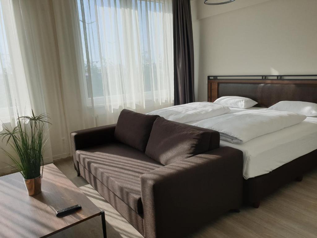 舍讷费尔德Motel Plus Schönefeld的卧室内的一张床和一张沙发