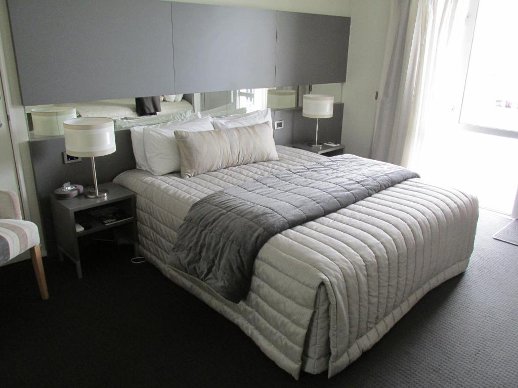 基督城机场通道汽车旅馆的一张大床,位于酒店带两盏灯的房间