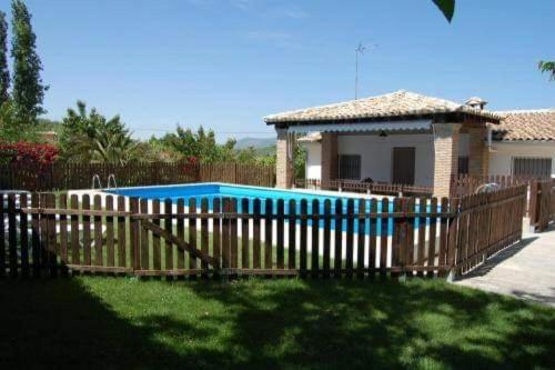 卡索拉Casa Esteban的一座带游泳池的房屋前的木栅栏