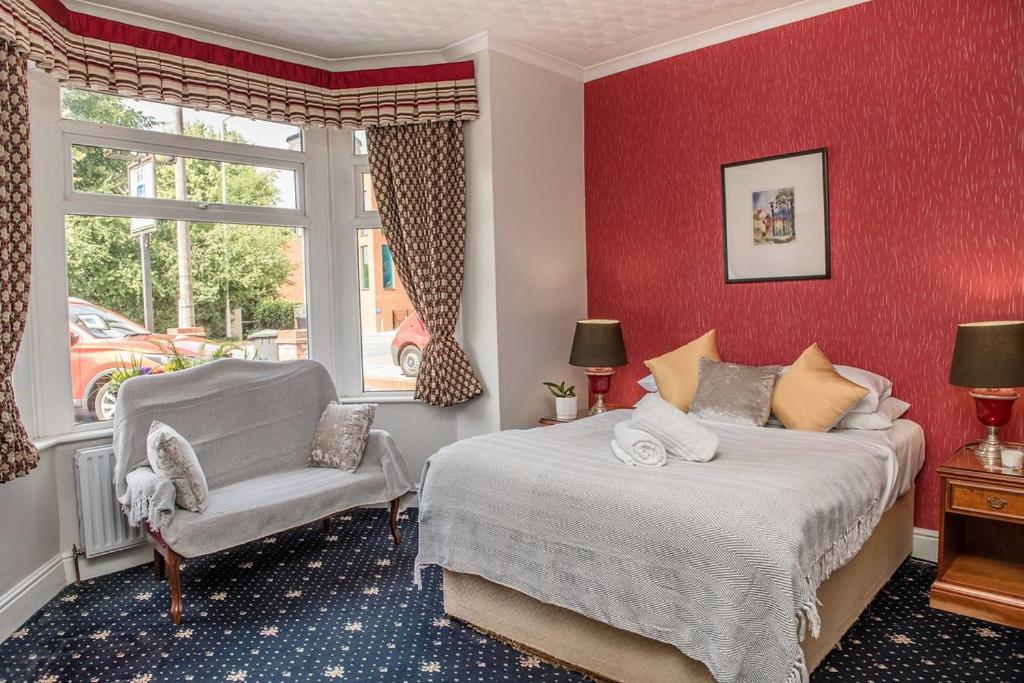 剑桥Crystal Hotel & Savour的一间卧室设有两张床、一把椅子和一个窗户。