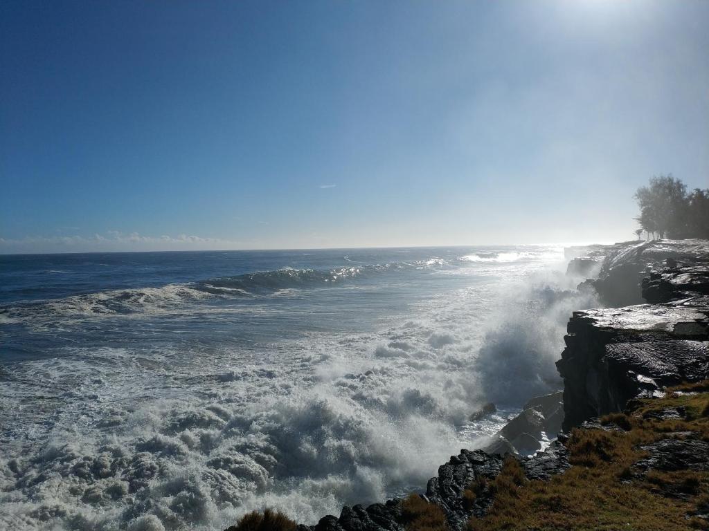 凯阿奥Ocean Breeze Inn的巨浪冲击了岩石海岸
