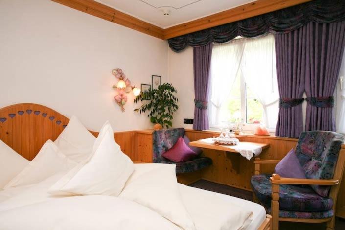 贝格诺伊施塔特林格瑟穆尔餐厅酒店的卧室配有一张床和一张桌子及椅子
