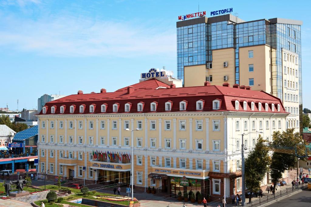 罗夫诺乌克兰罗夫诺酒店 的一座位于城市街道上的大型建筑,有一座高大的建筑