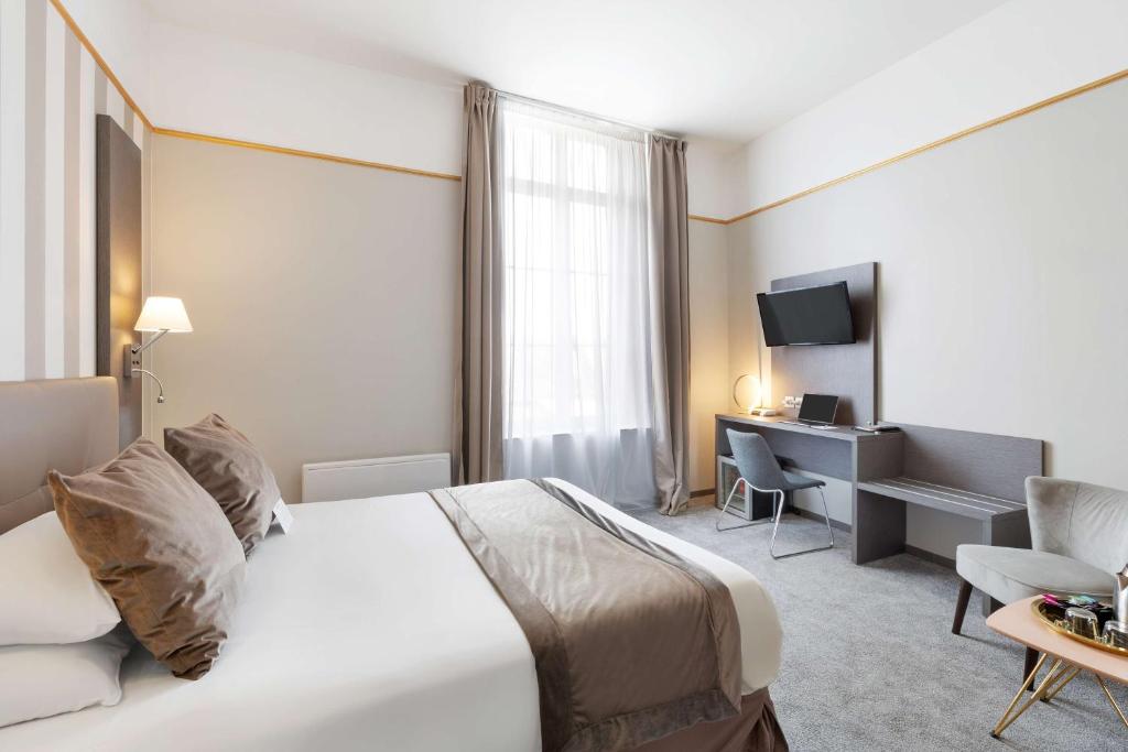 佩罗讷Best Western Hotel Saint Claude的酒店客房设有一张大床和一张书桌。