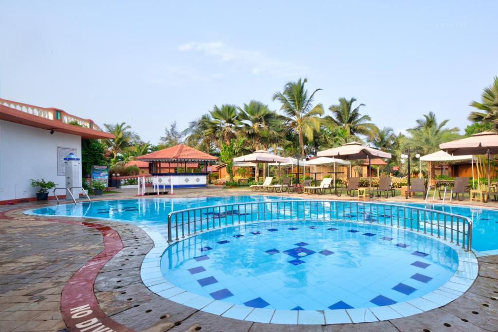 比纳里姆Beira Mar Beach Resort的度假村的游泳池,配有椅子和遮阳伞