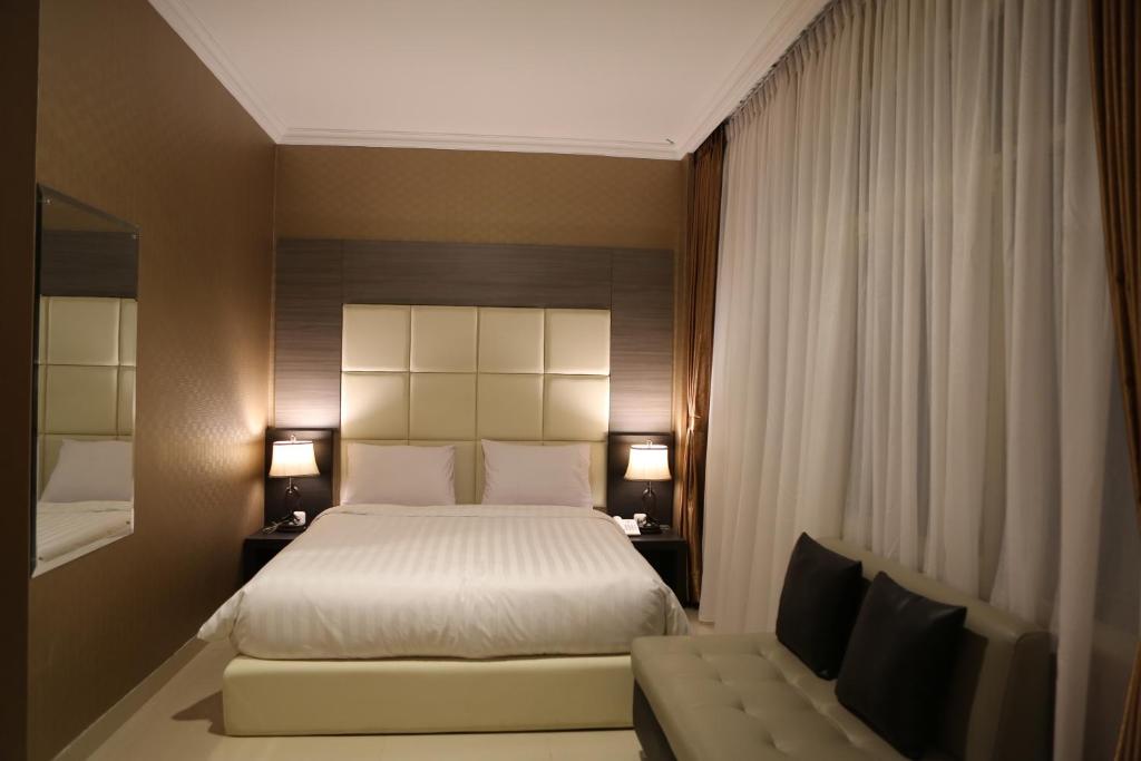 雅加达55号酒店的酒店客房,配有床和沙发