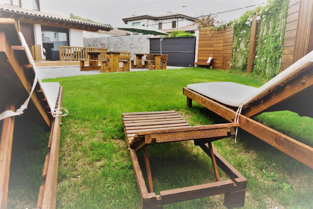利亚内斯Apartamentos La Playina的后院设有椅子、桌子和草坪