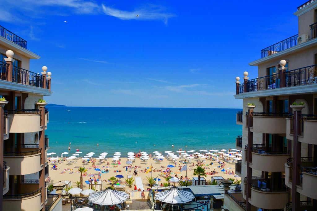 阳光海滩Golden Rainbow Beach Hotel的享有海滩美景,配有遮阳伞和海洋美景。