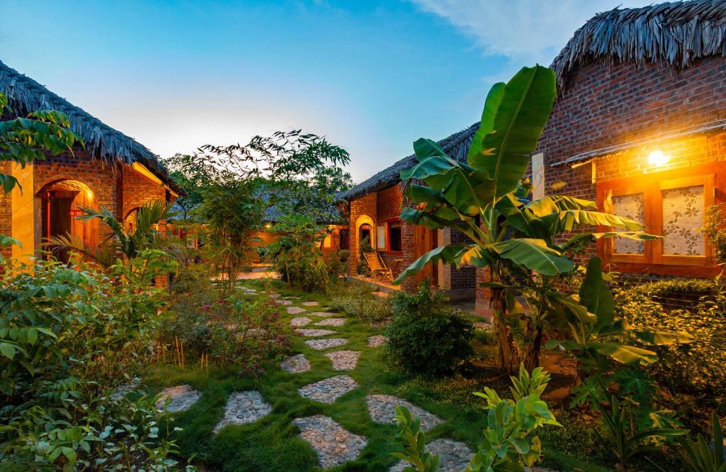 宁平Ninh Binh Palm Homestay的一座花园,位于一座带小径的房屋前