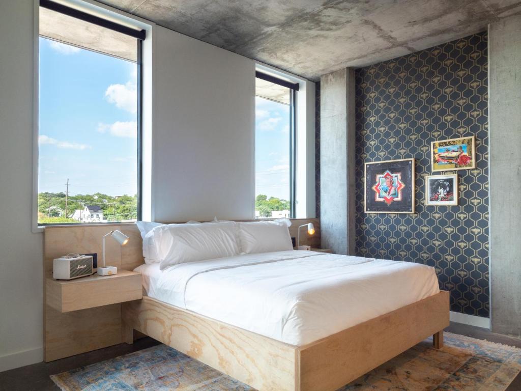 奥斯汀ARRIVE Austin的一间卧室设有一张大床和窗户