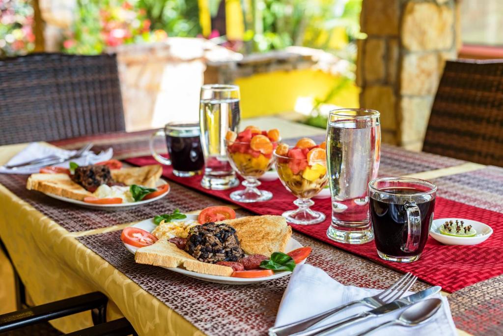 格雷西亚La Terraza Guest House B&B的餐桌,带食物盘和苏打水杯