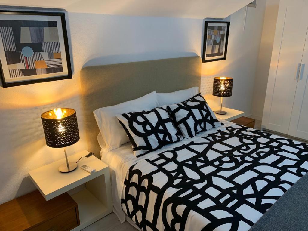 沙尔内卡House BLZ的一间卧室配有一张黑白床和两盏灯。