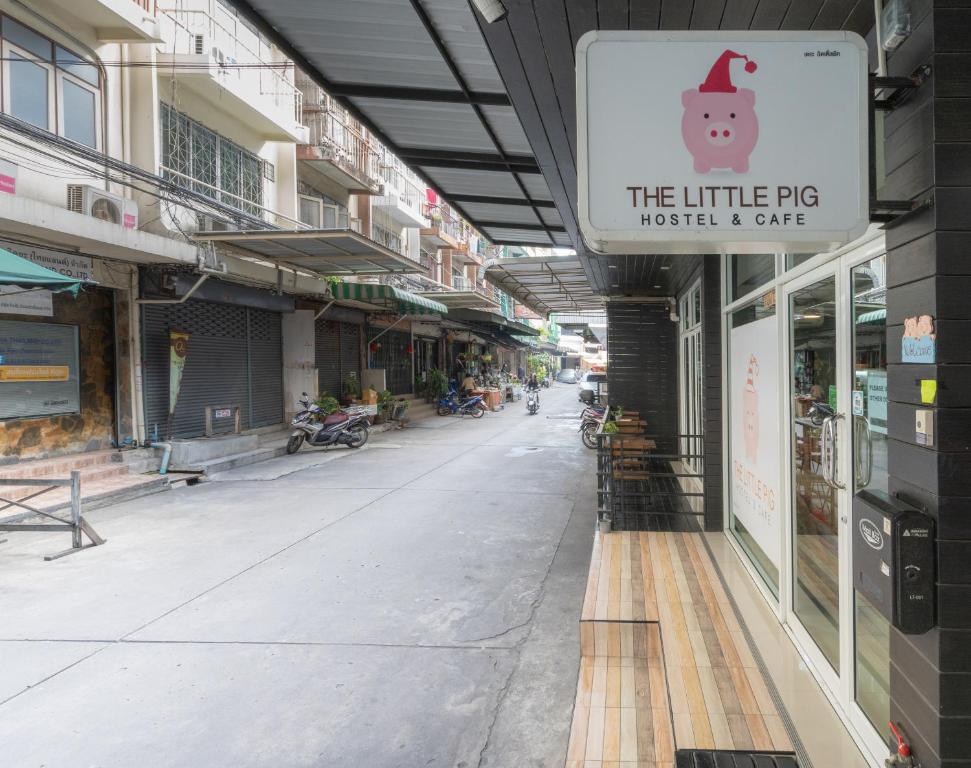 曼谷素坤逸路小猪旅舍的一条空的街道,上面有小猪市场和咖啡馆的标志
