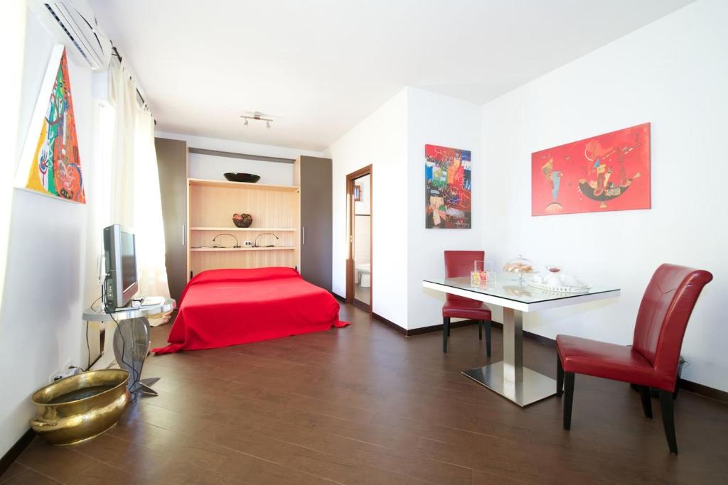 巴里Casa Turati的一间卧室配有红色的床和桌椅
