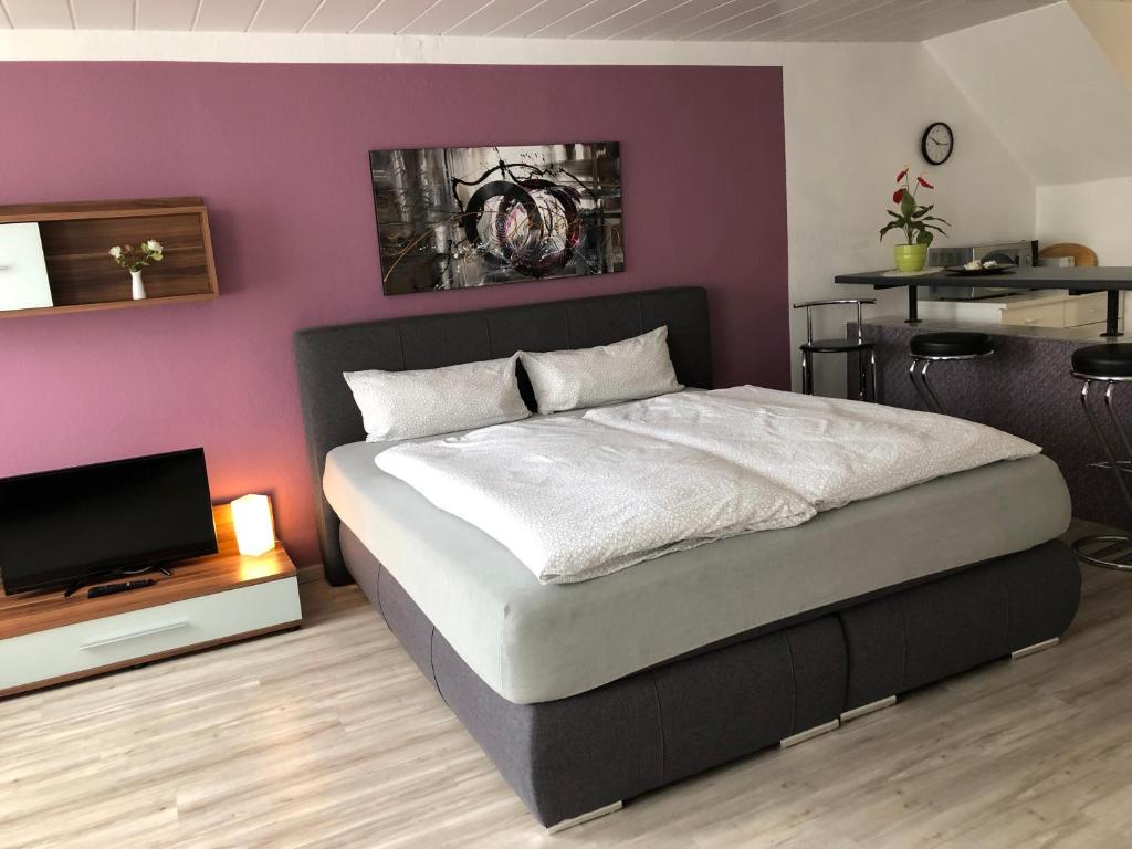 弗劳恩瓦尔德Haus Linde Frauenwald am Rennsteig的一间卧室配有一张床和紫色的墙壁