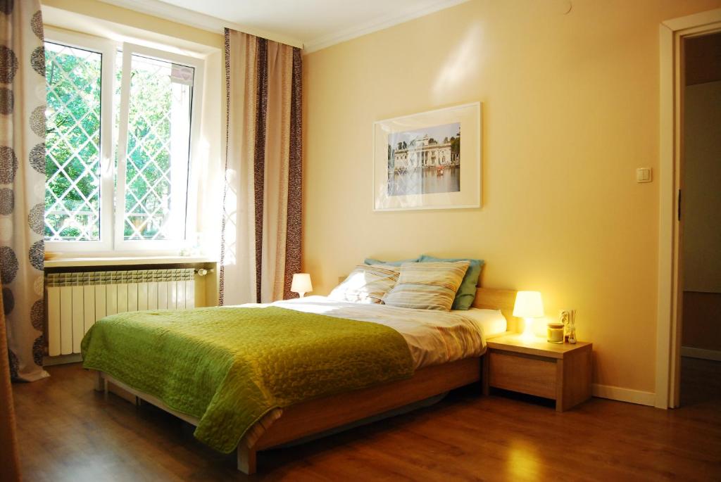 华沙Bed & Breakfast Sielce Warszawa的一间卧室配有一张带绿毯的床和窗户。