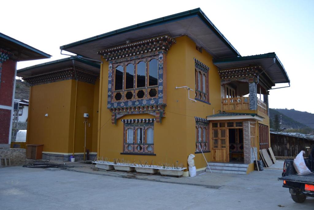 帕罗Yangkey Villa的黄色的建筑,旁边设有阳台