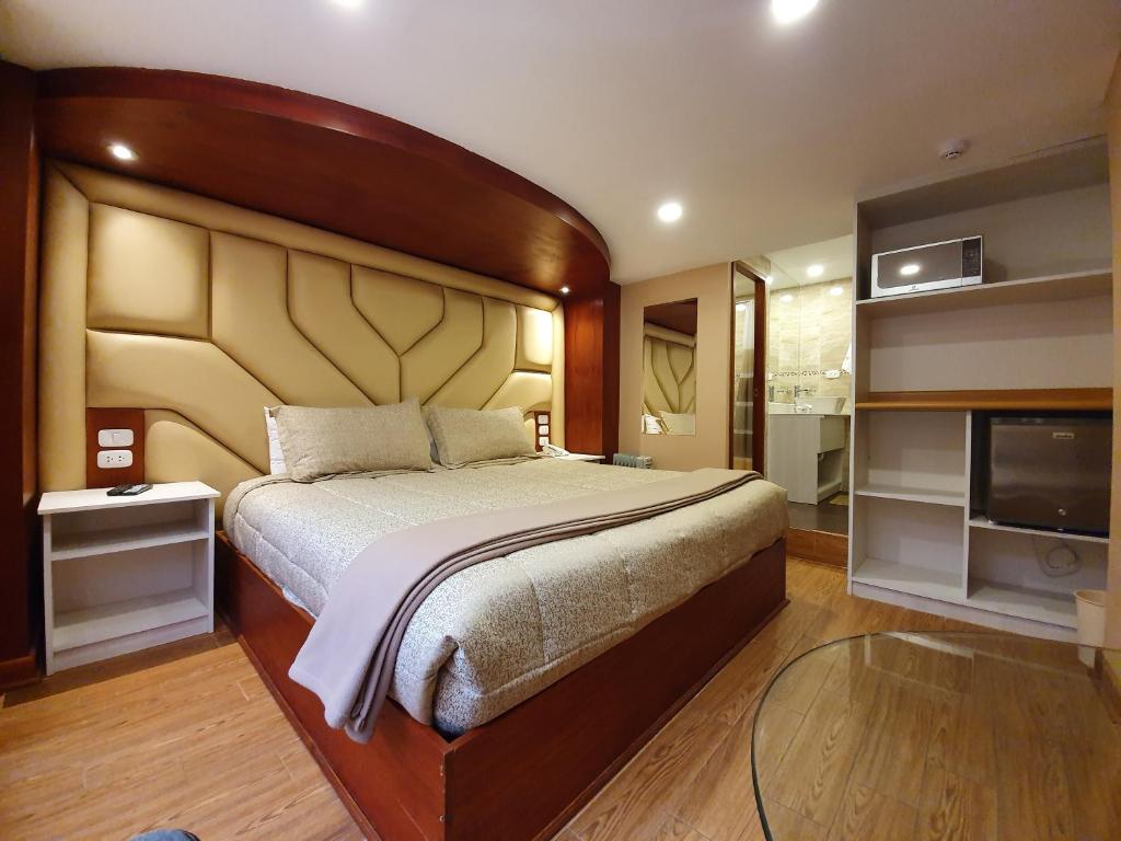 库斯科萨尔瓦多库斯科酒店的一间卧室配有一张大床和一台平面电视