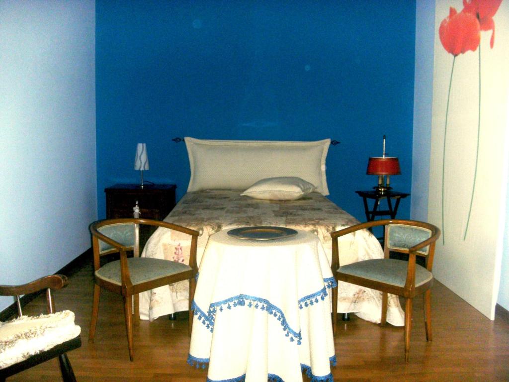 阿拉代奥Le Vallonee B&B的一间卧室配有一张带桌子和两把椅子的床