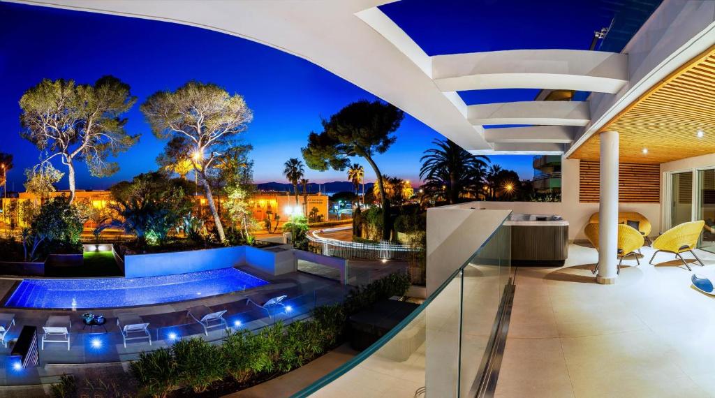 圣拉斐尔Villa Catleya Appart Hôtel的一座晚上设有游泳池的房子