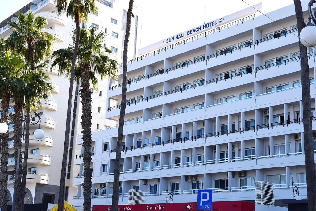 拉纳卡太阳堂海滩酒店公寓 的一间白色的酒店,前面有棕榈树