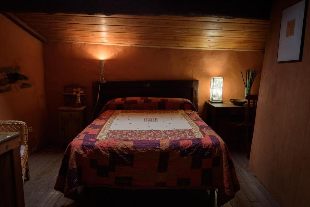 TraguntiaCasa Rural Caenia Grupos的一间卧室配有床,床上装有被子