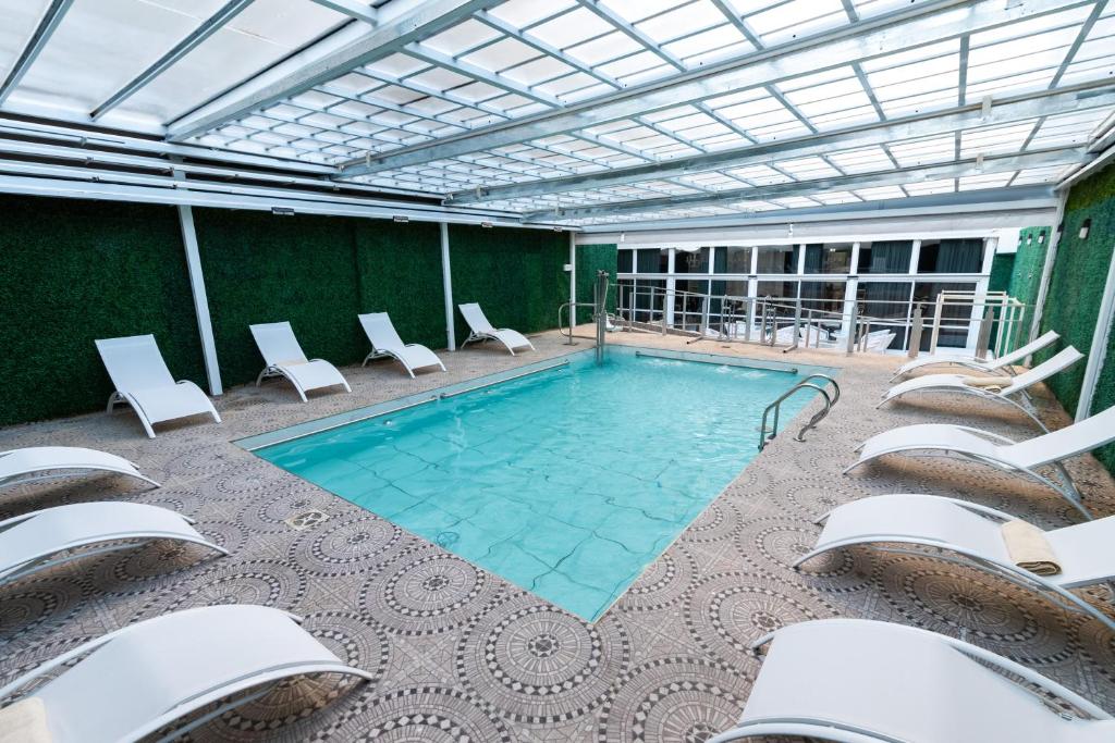 布宜诺斯艾利斯Ker San Telmo Hotel的一个带椅子和泳池景的大型游泳池