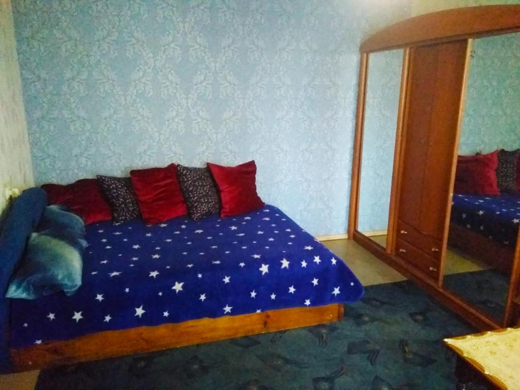 OkhtyrkaКвартира на Ленина的一间卧室配有一张带红色枕头和镜子的床