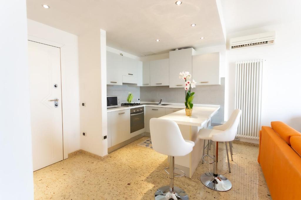 索托马里纳Le Murrine Frontemare Apartment Seaview的厨房以及带桌椅的起居室。