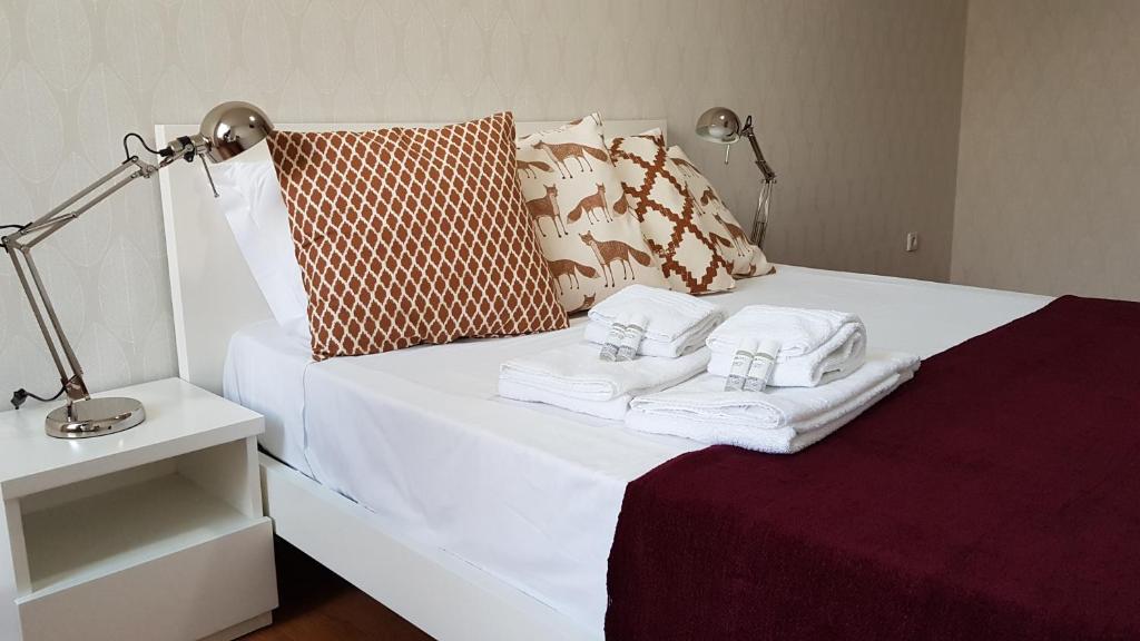 波尔图布拉加斯一室公寓的一张带毛巾和灯的白色床
