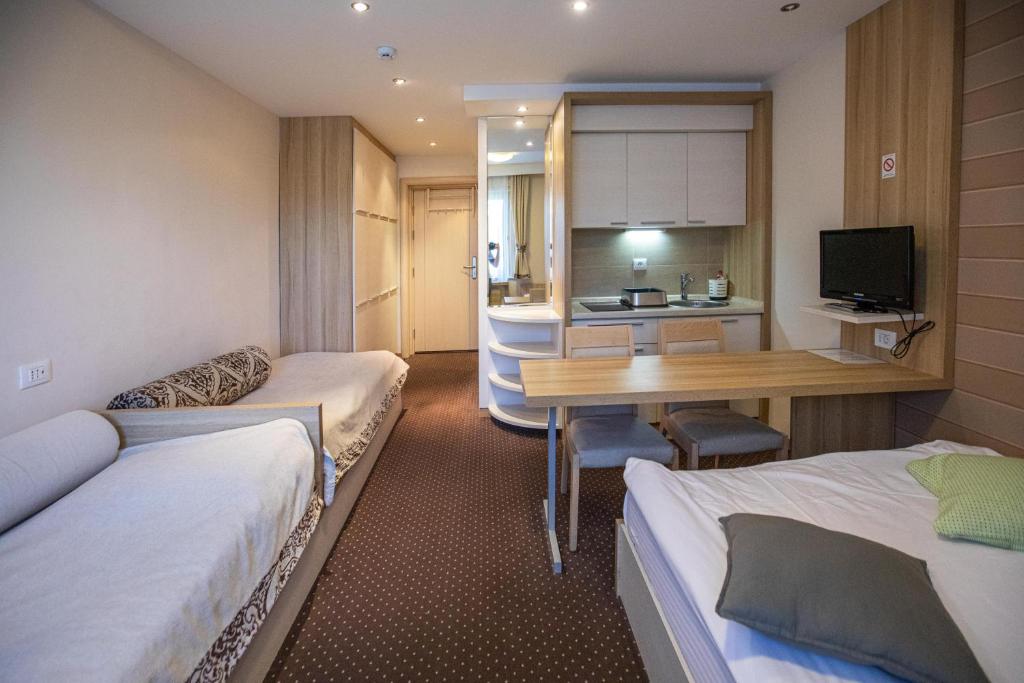 科帕奥尼克Apartments Suncani Vrhovi Kopaonik的酒店客房配有两张床和一张书桌