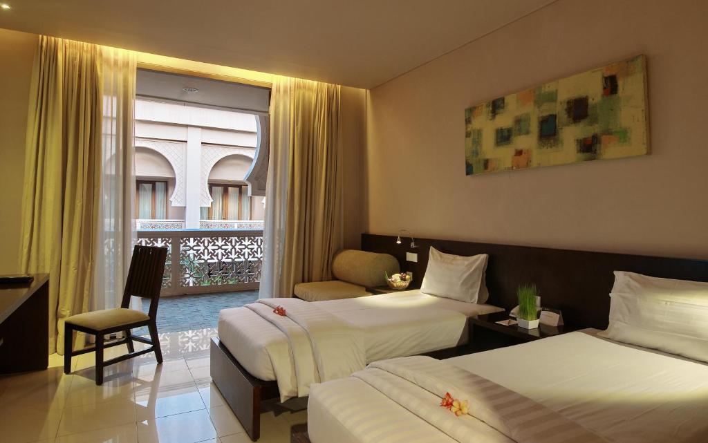 班达亚齐The Pade Hotel的酒店客房设有两张床和窗户。