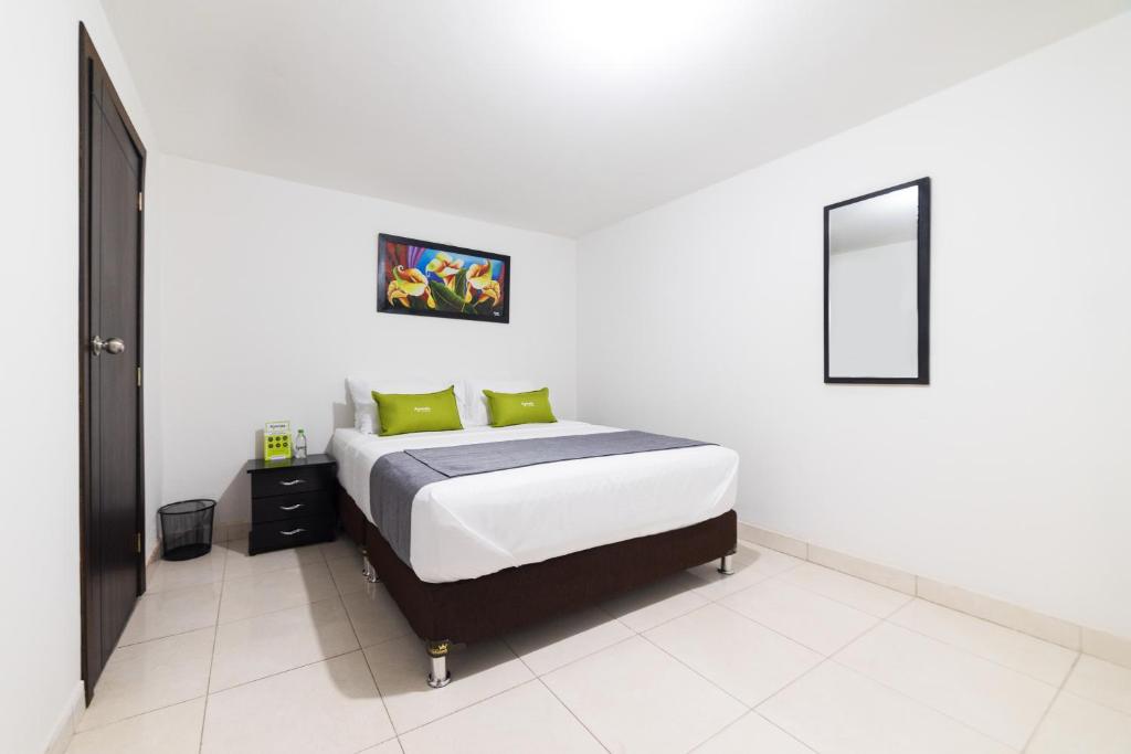波哥大Ayenda 1045 Boutique Aeropuerto的白色卧室配有带绿色枕头的床