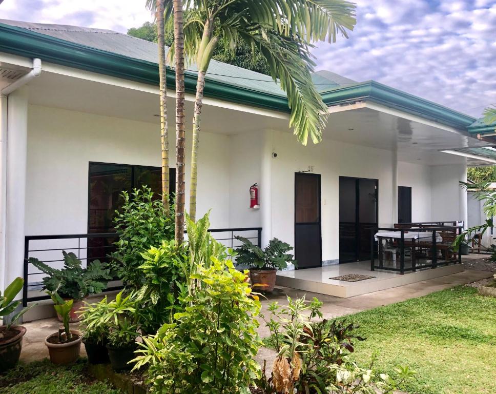 曼巴豪Paguia’s Cottages的前面有棕榈树的房子