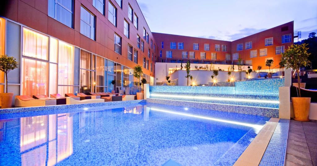圣马丁娜穆里Hotel Terme Sveti Martin的酒店游泳池设有椅子,酒店大楼
