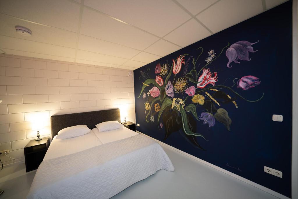 莱米尔Beach Suites Lemmer的卧室的墙上挂有花卉画