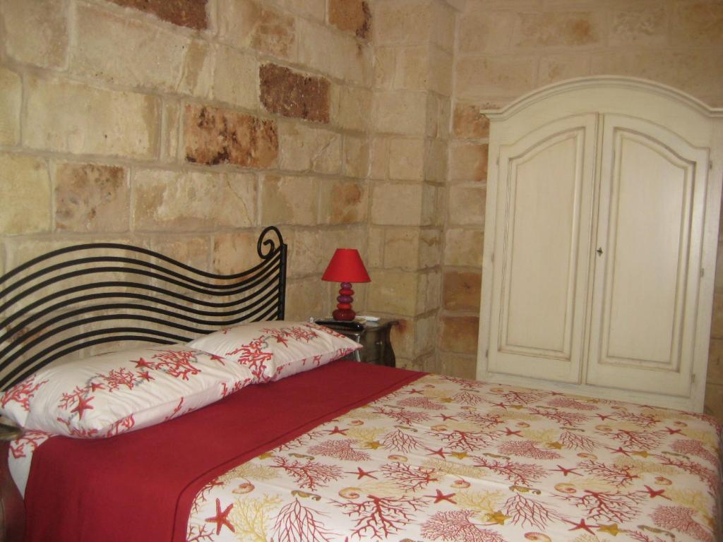 切萨雷奥港Grekal Bed Salento的一间卧室设有一张床和石墙