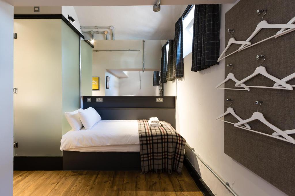 爱丁堡CoDE Pod – The CoURT - Edinburgh的卧室配有一张床和挂在墙上的衣架