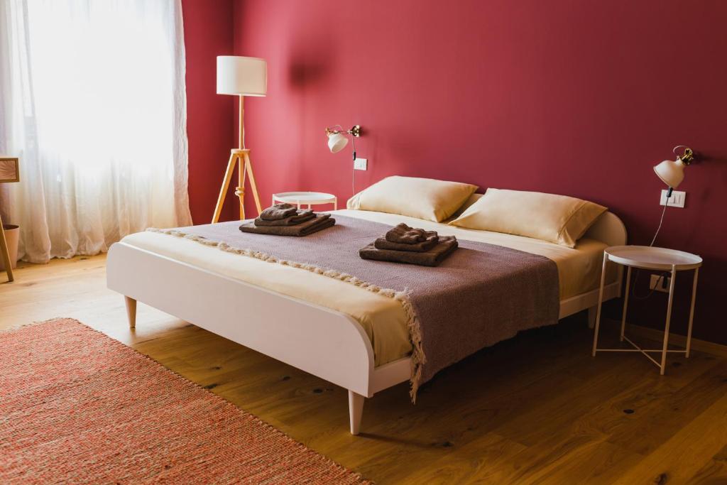 的里雅斯特B&B Adelaide的一间卧室设有一张红色墙壁的大床