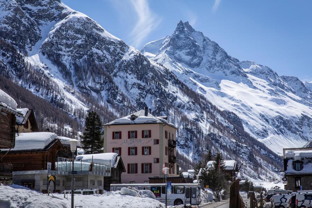 琪纳尔Hôtel Le Besso - Swiss Romantic Lodge Zinal的雪覆盖的山前的建筑物