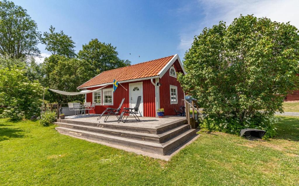 GisseboFårbo的一座红色的房子,在院子里设有木甲板