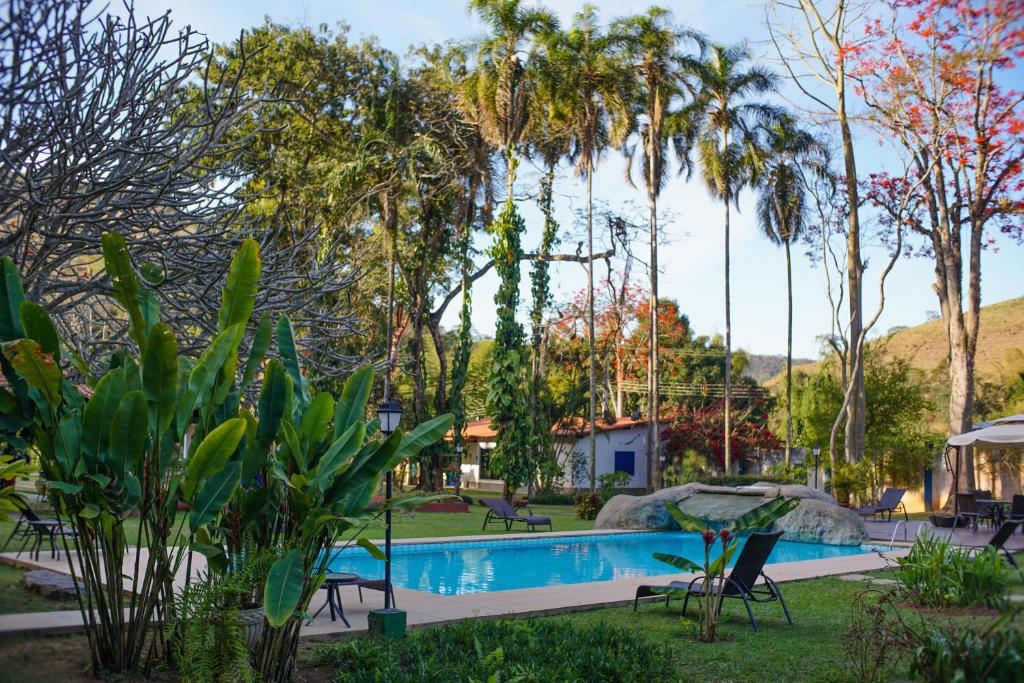 BarrinhaHotel Fazenda Bela Riba的棕榈树庭院内的游泳池