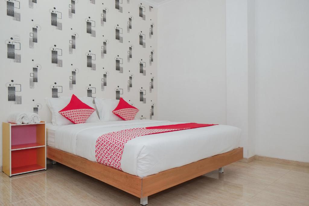 巴图OYO 1454 111 Residence的一间卧室配有红色枕头的床